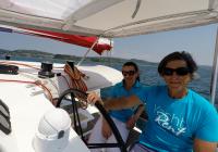 skipper and girl behind steering wheel of trimaran neel 45 yacht 3